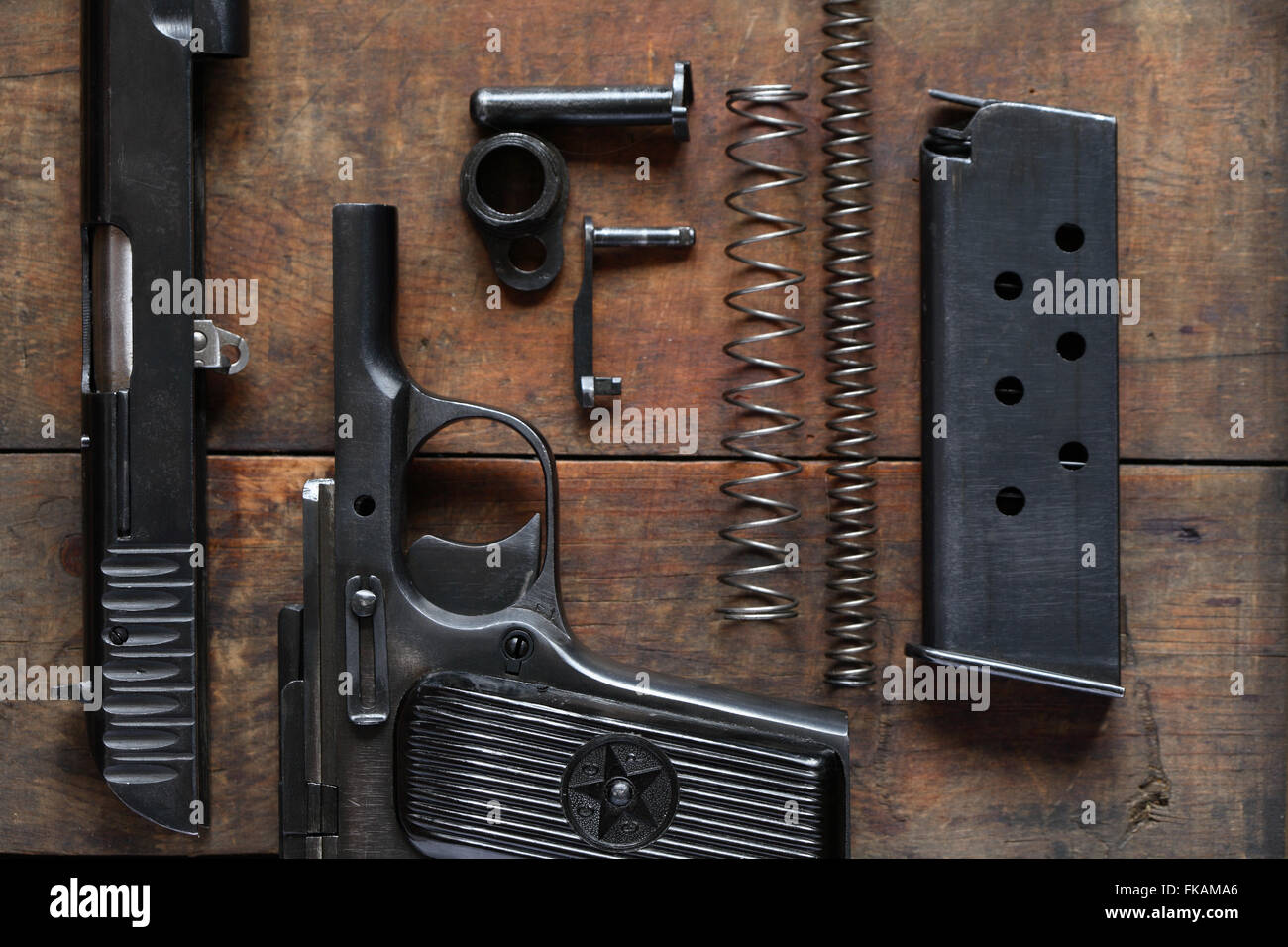 Soviet dismantled handgun on old wooden background Stock Photo