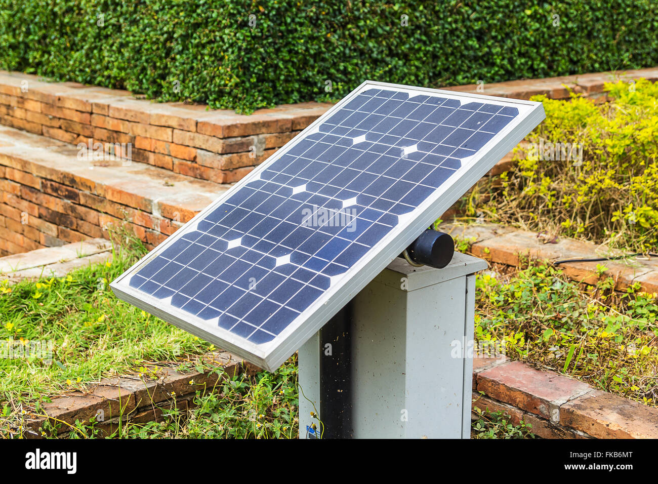 Mini stand electric solar cell in a garden. Stock Photo