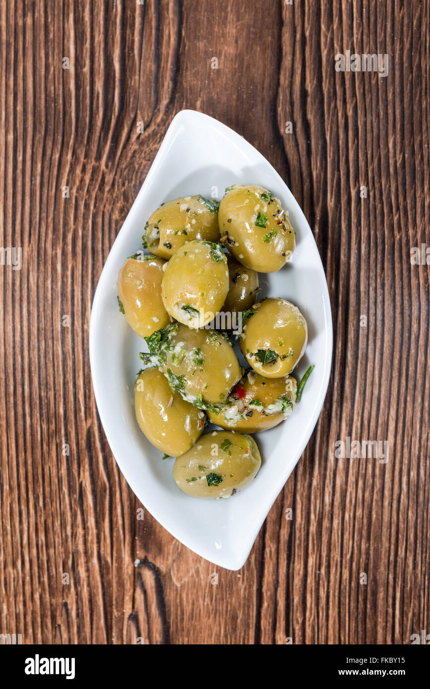 Green pickled Olives (close-up shot) with garlic and fresh herbs Stock Photo