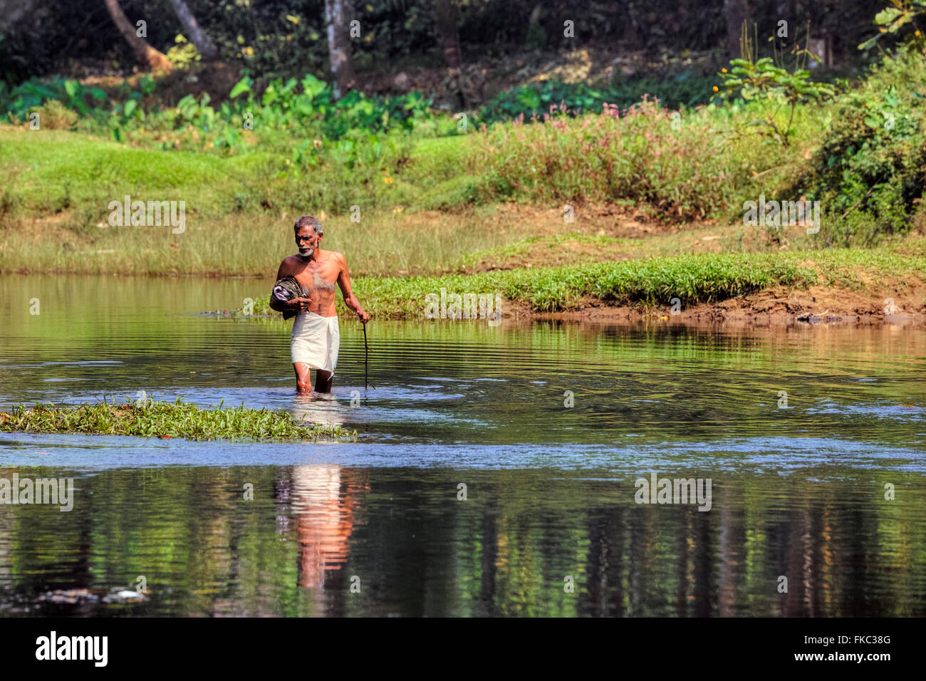a man walking in the river in Kerala, South India Stock Photo