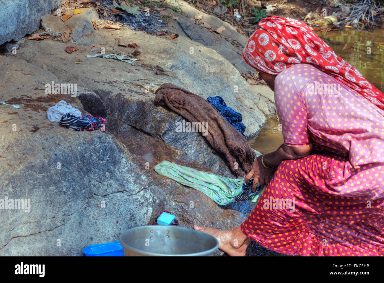 a woman doing the laundry in a river in Kerala, South India Stock Photo