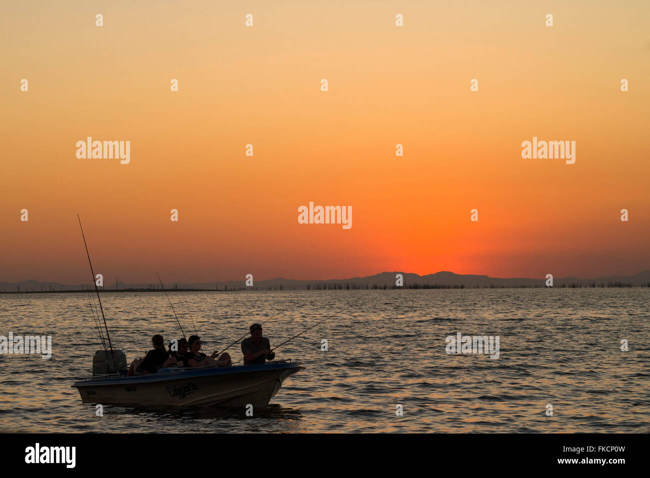 Sunset Lake Kariba boat fishing people tiger fish Stock Photo