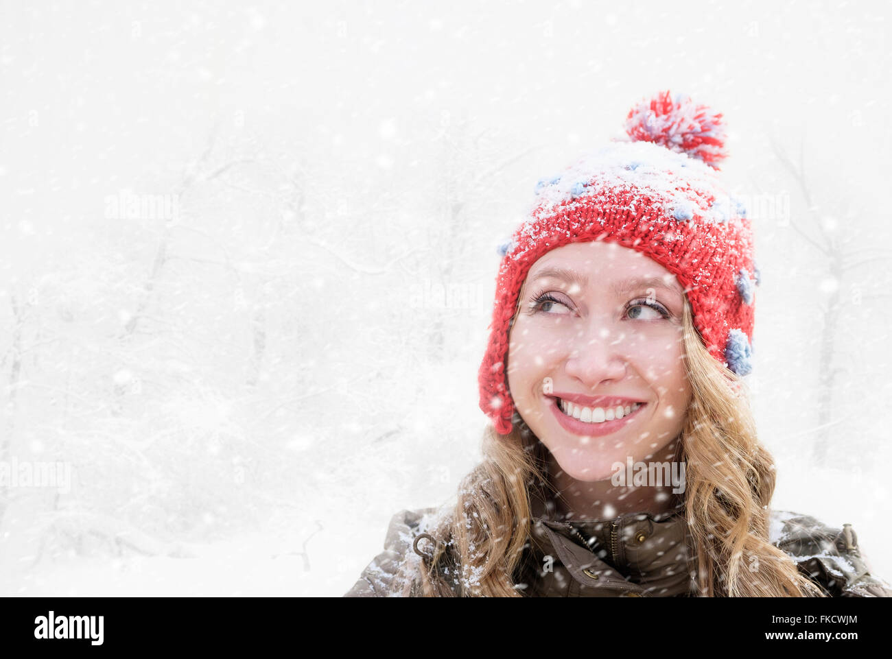 Woman in red knit hat looking away Stock Photo