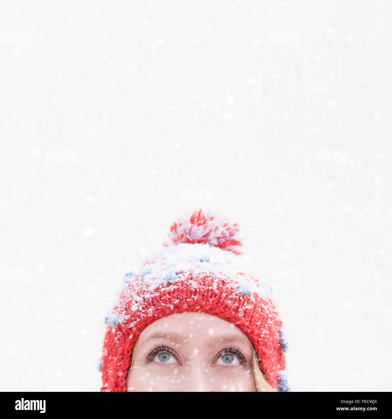 Woman in red knit hat looking up Stock Photo