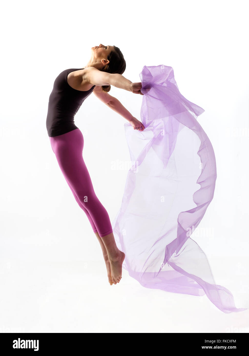 Woman with sheer fabric jumping Stock Photo