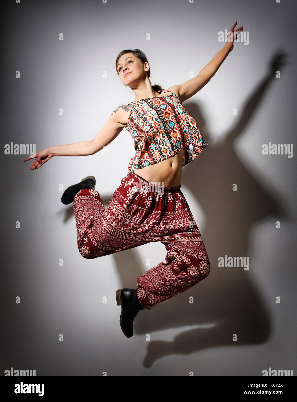 Young woman jumping against white background Stock Photo