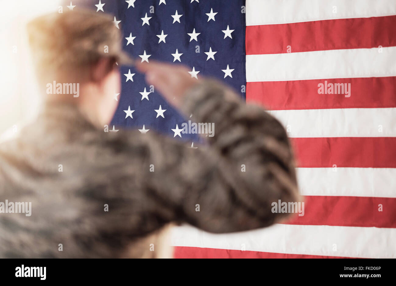 Soldier saluting American flag Stock Photo