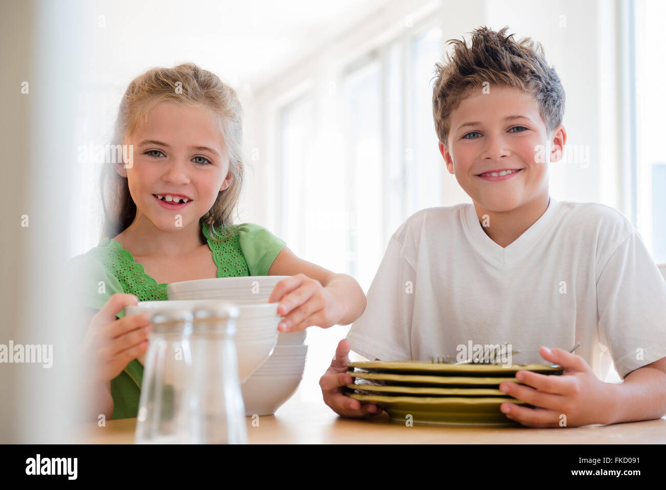 Brother and sister (6-7, 8-9) setting table Stock Photo