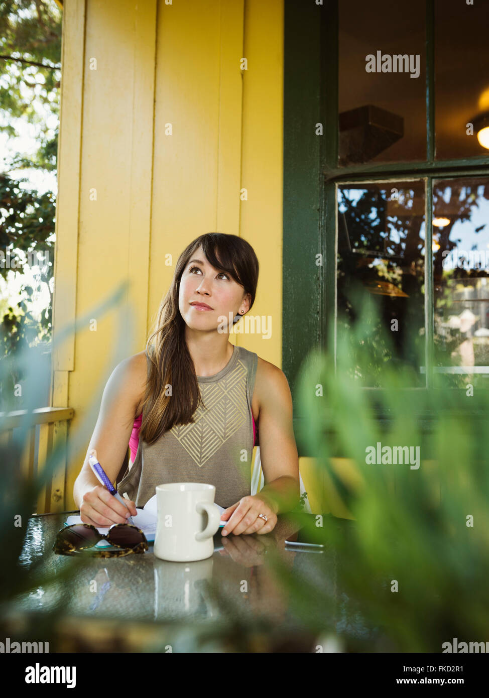 Young woman sitting on porch looking up Stock Photo - Alamy