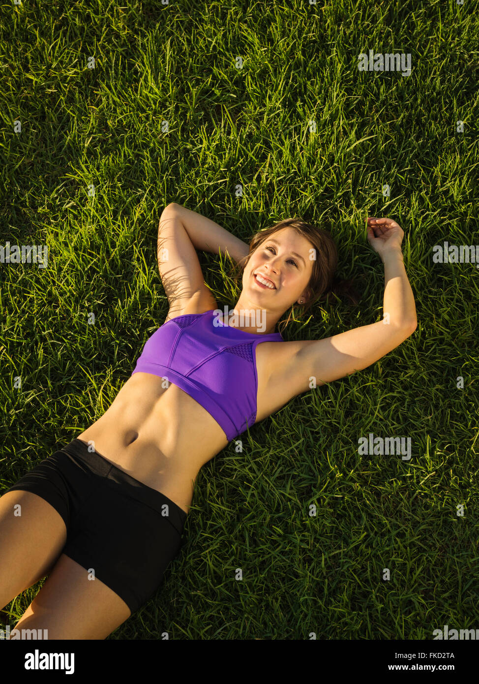Young woman lying on grass Stock Photo - Alamy