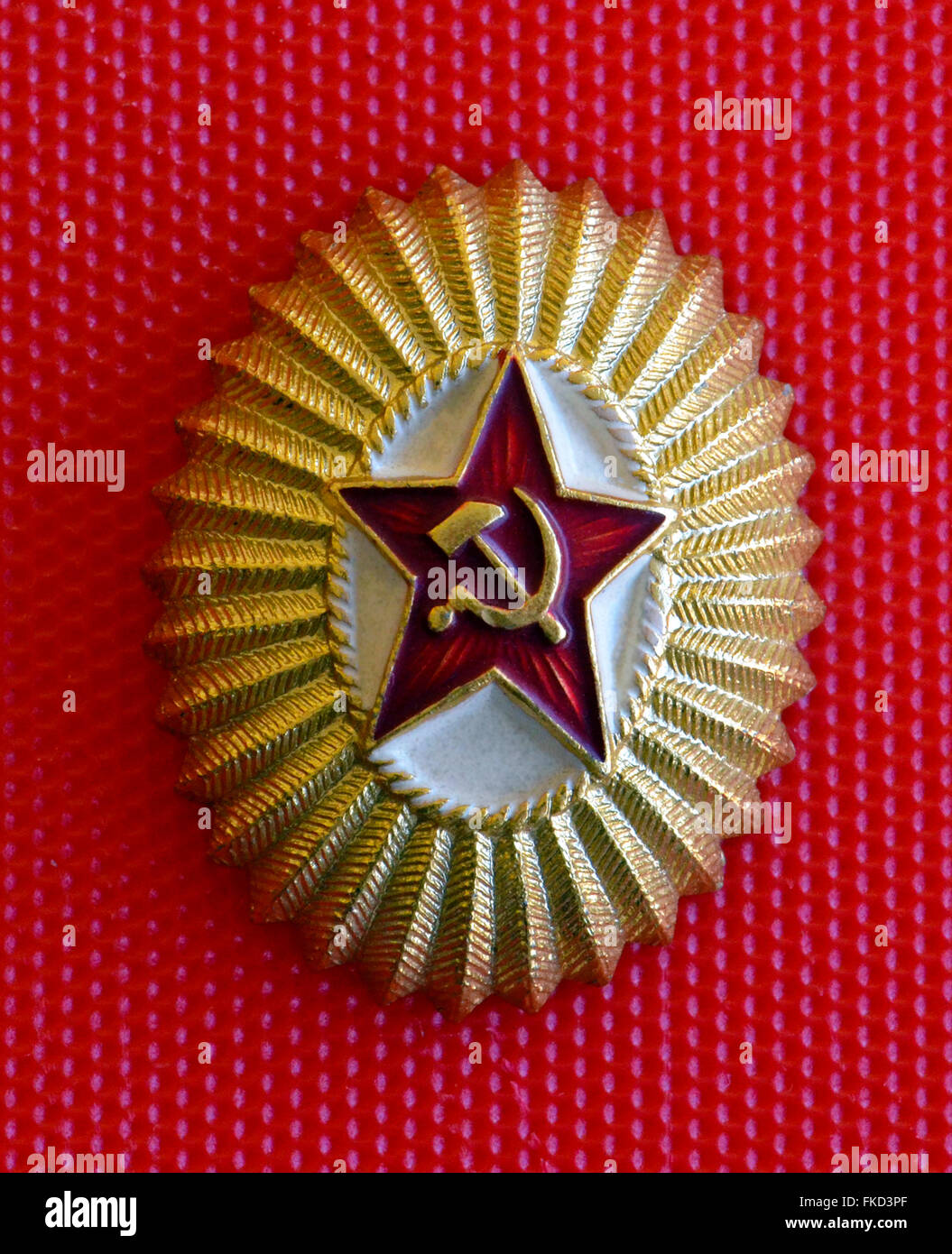 A popular badge of the Soviet Union shows a red star with the hammer and sickle, a Communist symbol created for the Russian Revolution of 1917. It was given to an American visitor in the USSR (Union of the Soviet Socialist Republics) in 1962 during the Cold War. This oval lightweight metal emblem measures 1-3/16 inches in the short dimension by 1-7/16 inches in the long dimension. Stock Photo