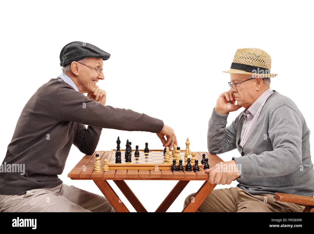 Studio shot of two old friends playing a game of chess at a wooden table isolated on white background Stock Photo