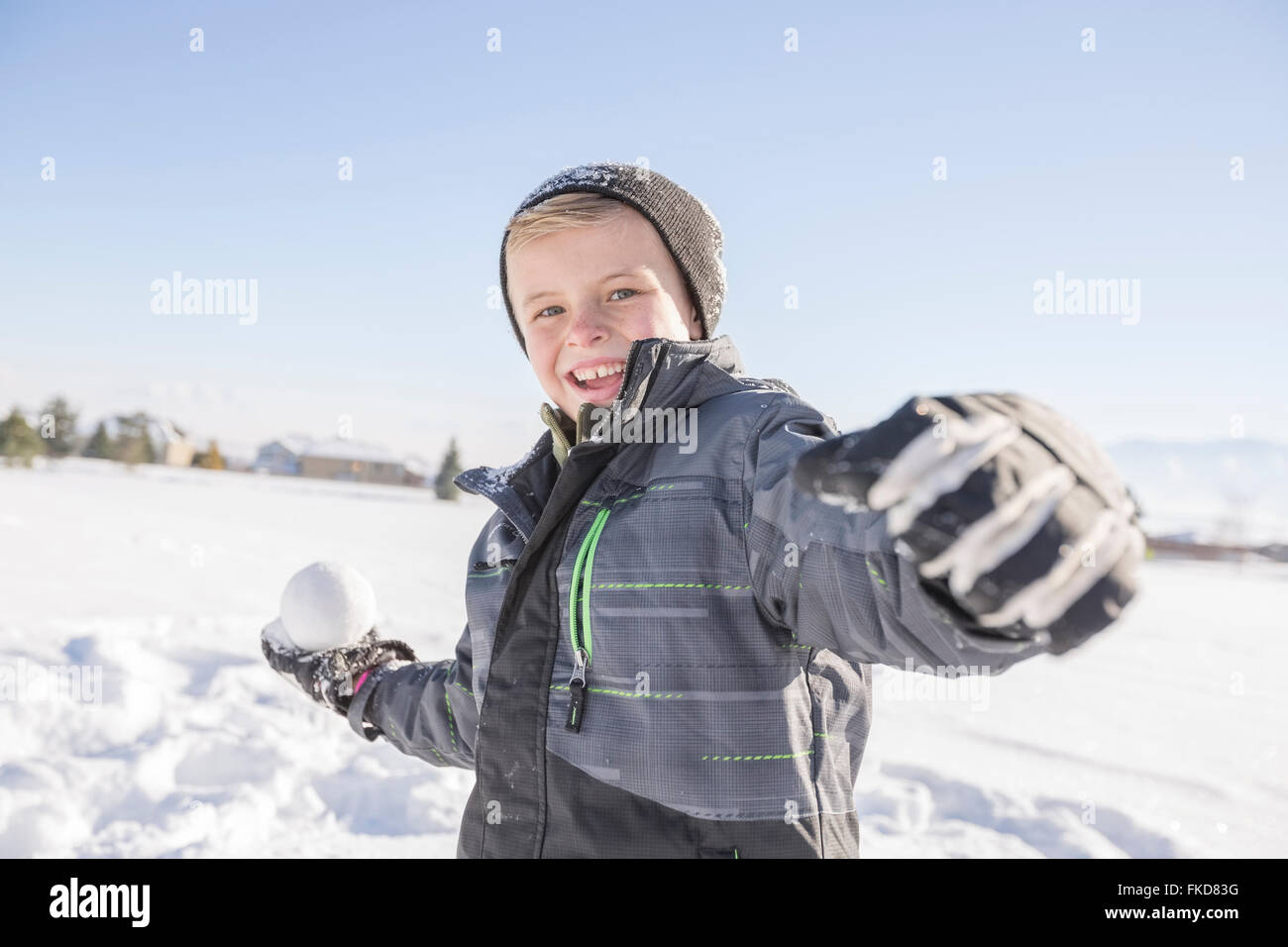 Boy (8-9) throwing snowball Stock Photo