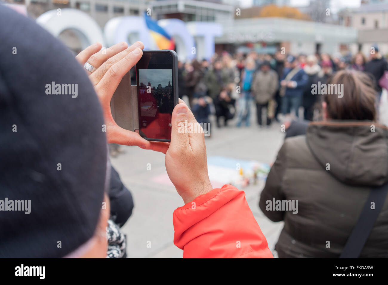 Man capturing an image with his mobile phone at Nathan Phillips Square, Toronto, Ontario, Canada Stock Photo