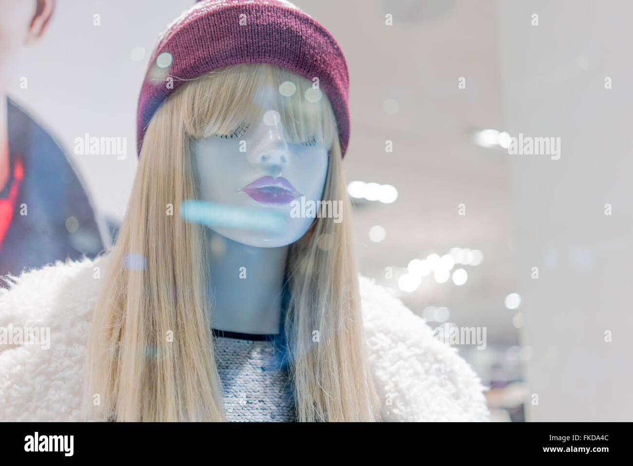 Mannequins wearing fur coat and knit hat in a clothing store Stock Photo