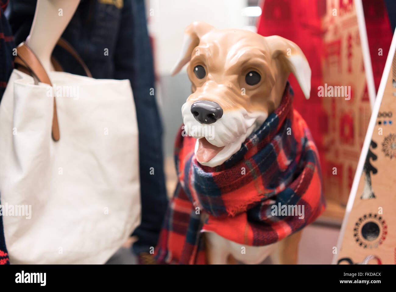 Mannequin of dog displaying dog clothing and scarf in clothing store Stock Photo