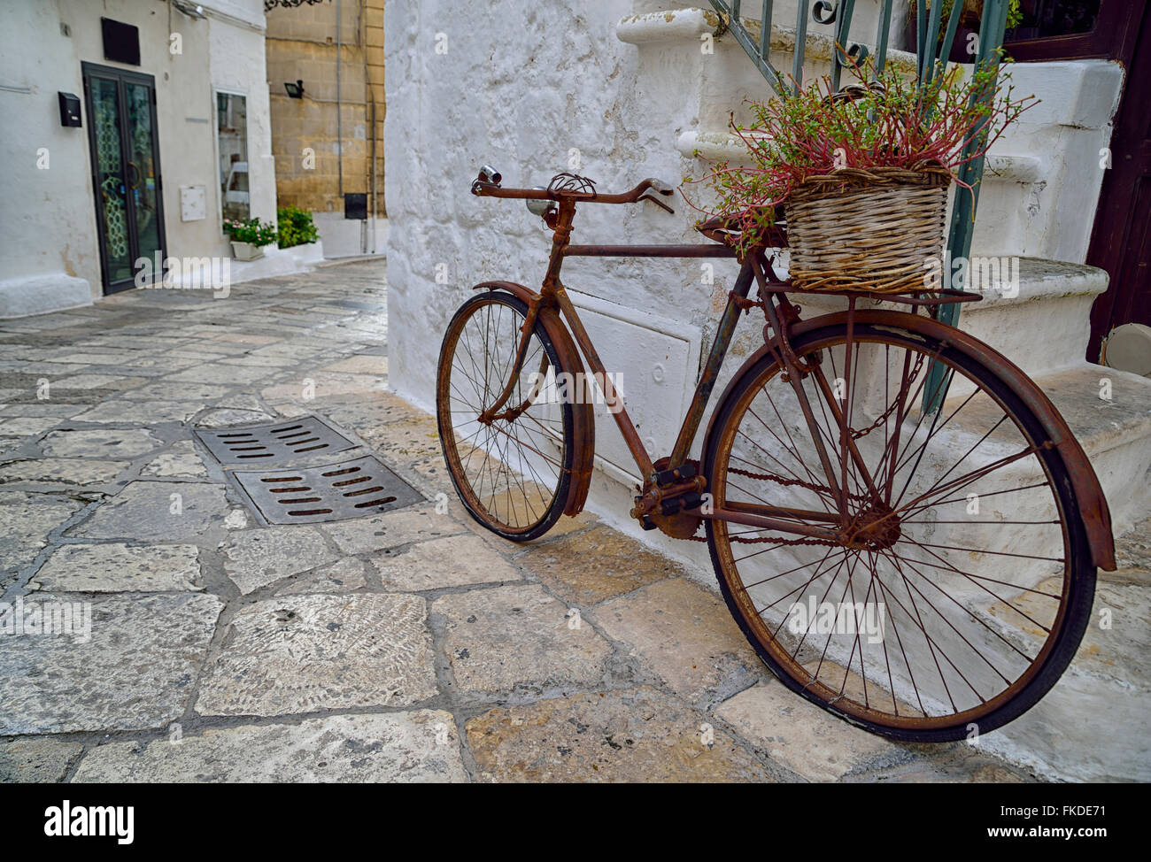 Old rusty bicycle with flower basket by steps Stock Photo