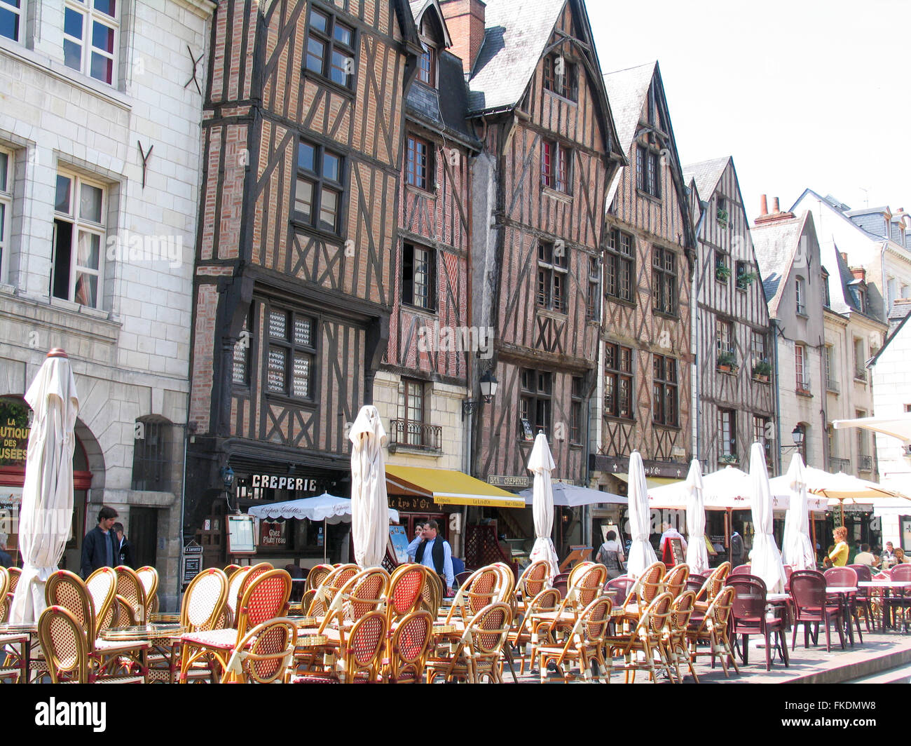 Tables and chairs used for al fresco dining outside a row of half timbered houses in Tours. Stock Photo