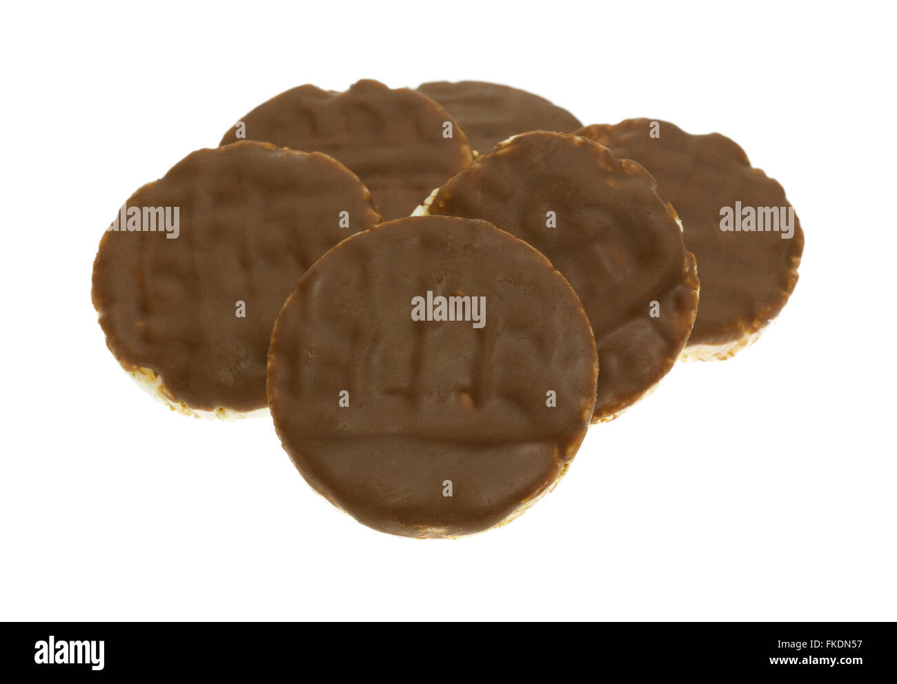 Side view of a group of organic rice cookies with milk chocolate icing isolated on a white background. Stock Photo