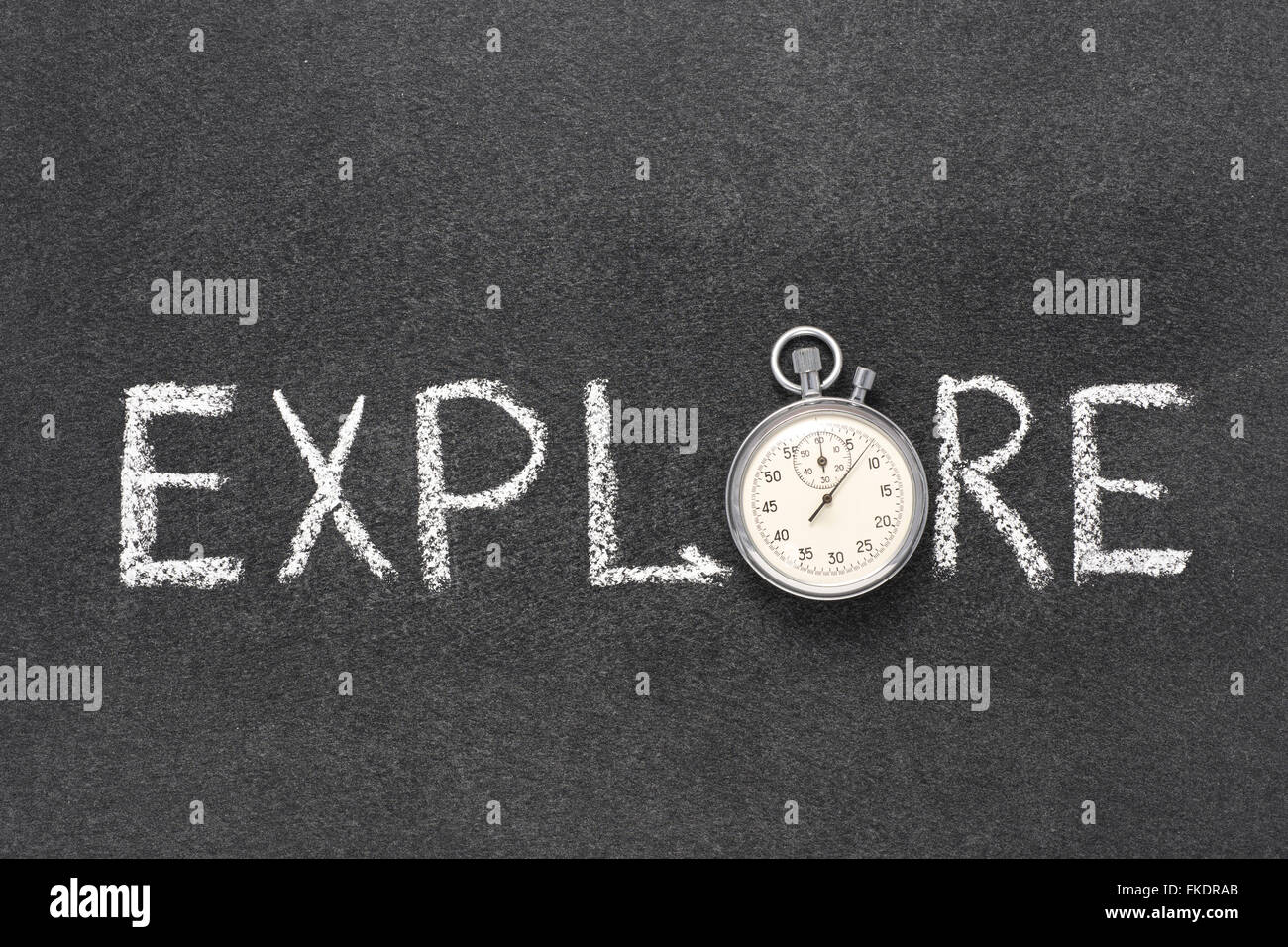 explore word handwritten on chalkboard with vintage precise stopwatch used instead of O Stock Photo
