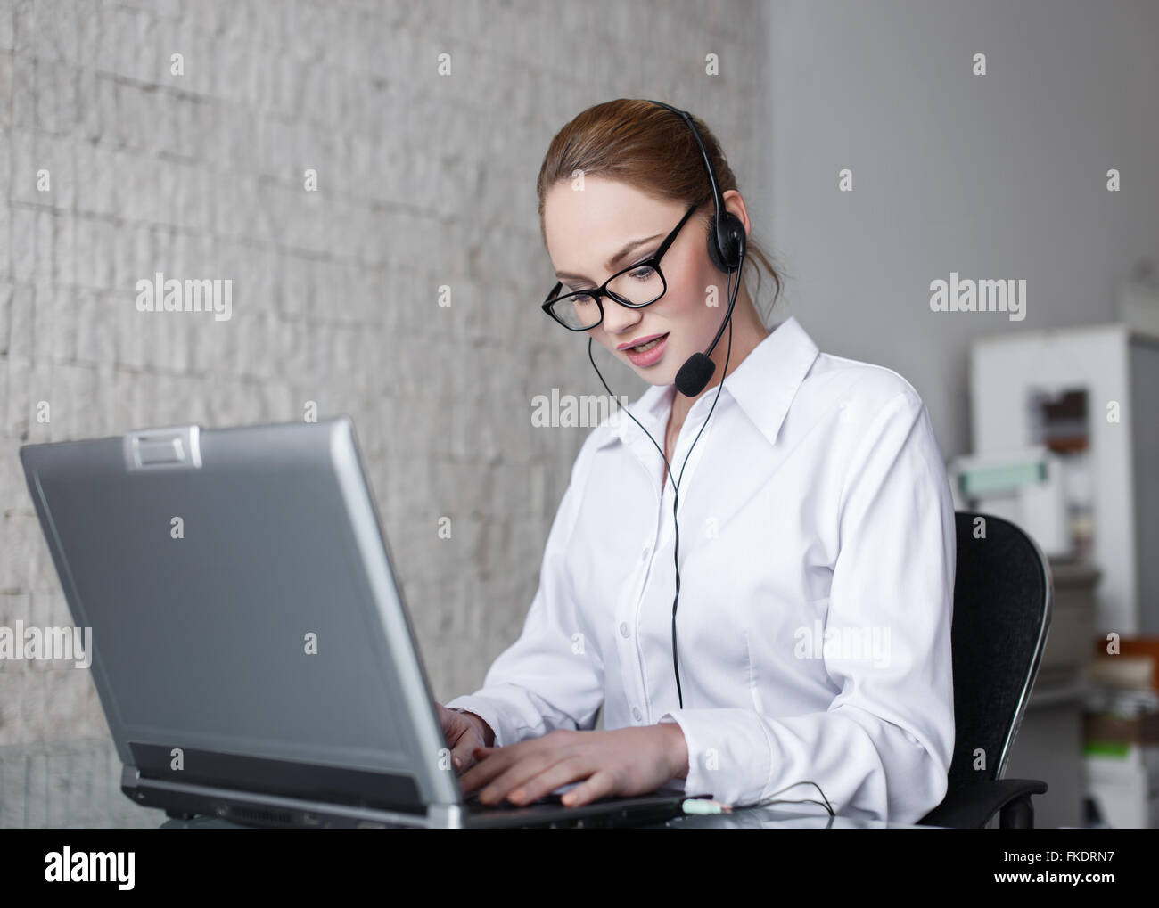 Blonde woman customer support in company, talking online Stock Photo