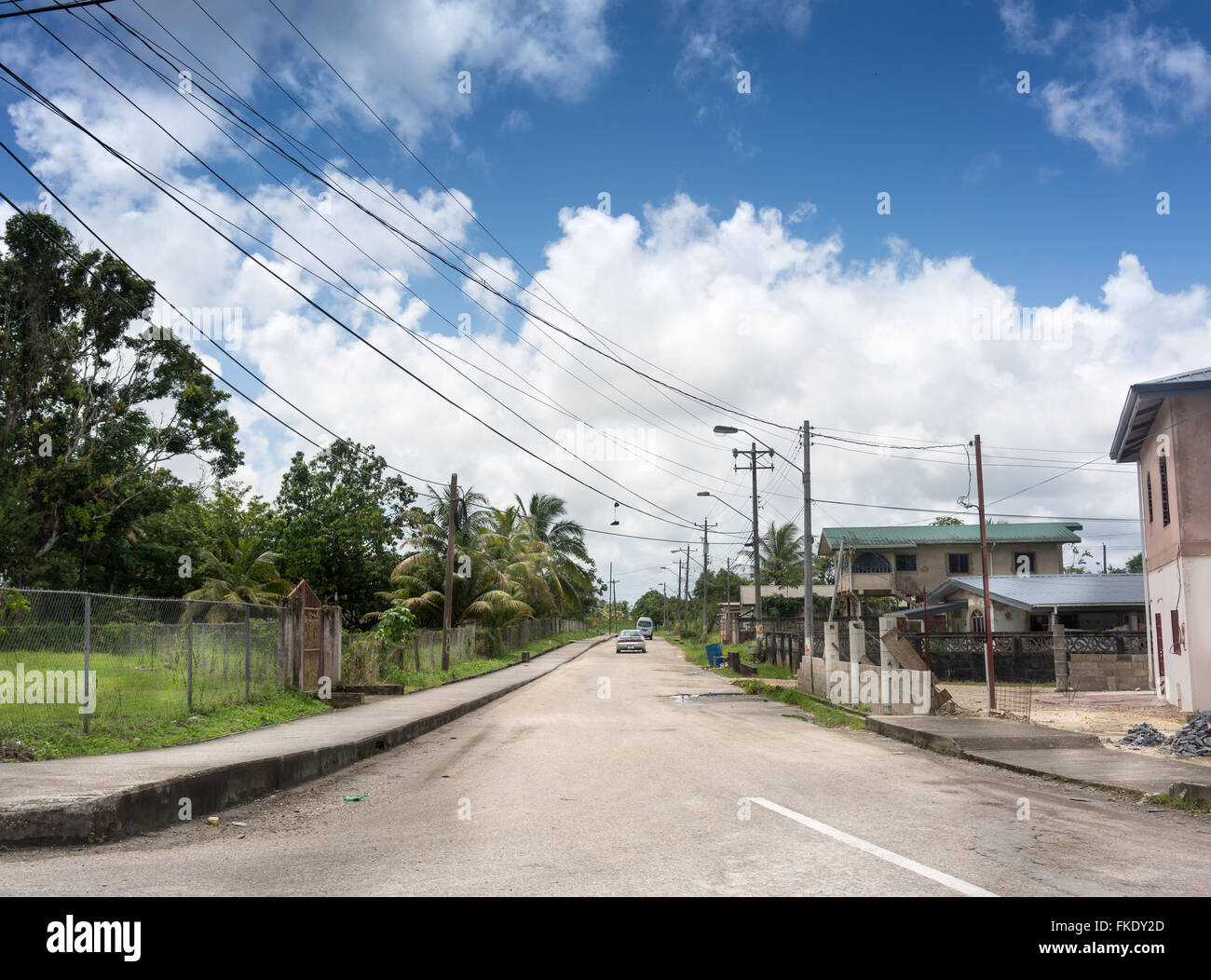 Cars on road along with houses against cloudy sky, Trinidad, Trinidad And Tobago Stock Photo