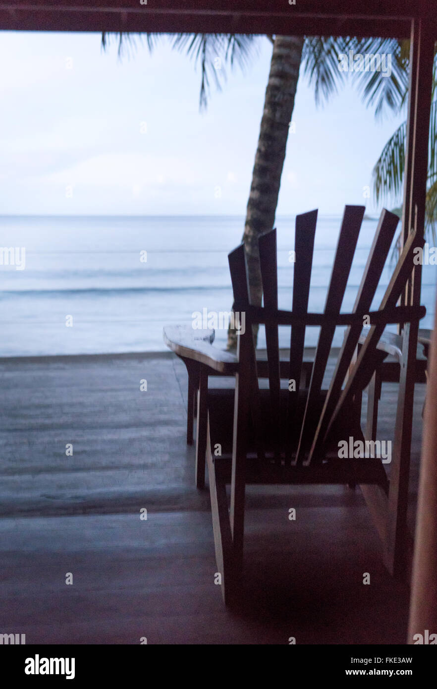Adirondack chair at a tourist resort and sea viewed from open door of a tourist resort, Trinidad