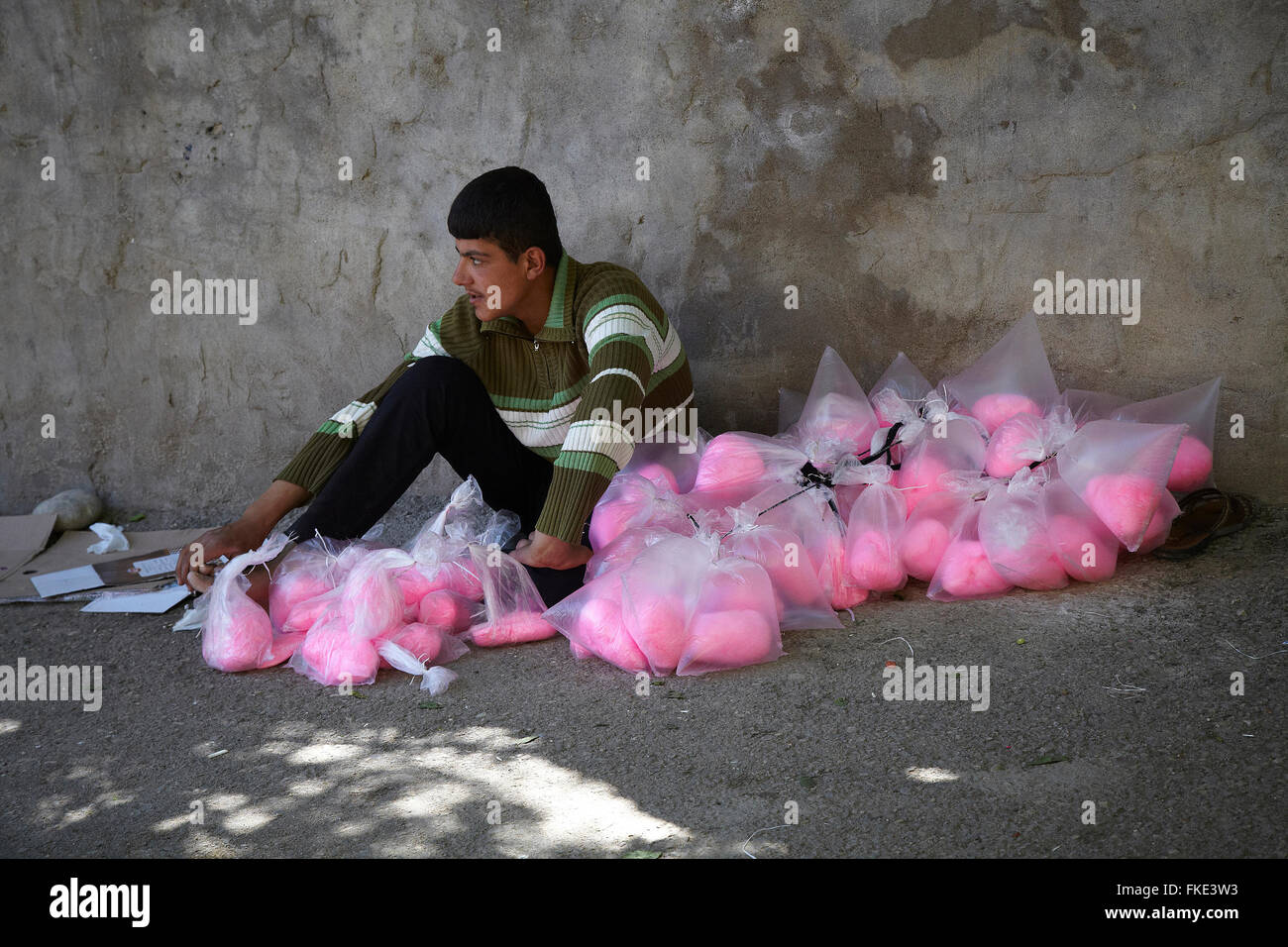 A young refugee boy selling colored candy-floss inside the holy Yazidi temple in Lalesh. Iraqi Kurdistan Stock Photo