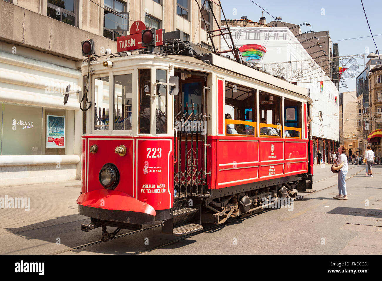 A tourist standing beside a tram, Istiklal Street, Beyoglu District, Istanbul, Turkey Stock Photo