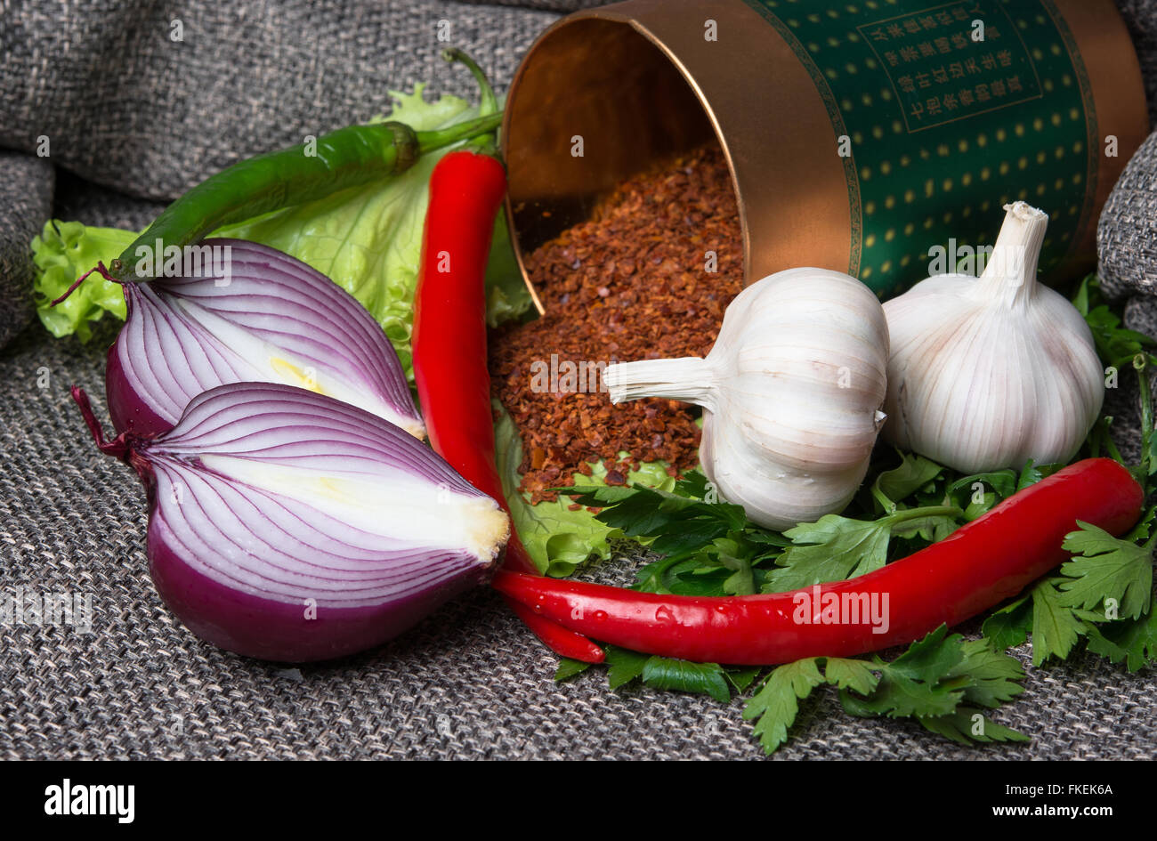 three chili peppers with garlic and fresh herbs Stock Photo