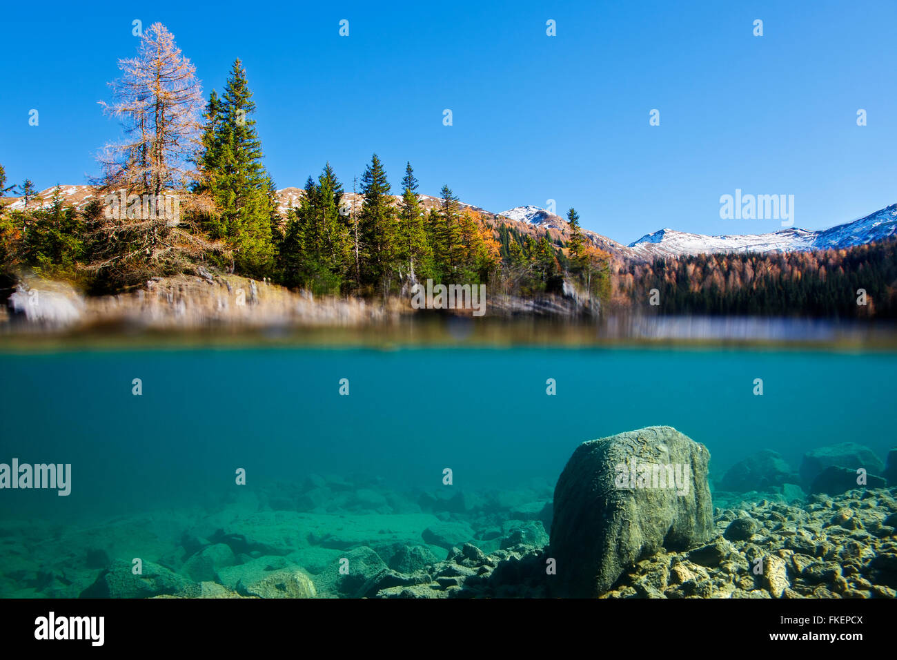Split picture, Obernberger See underwater picture merged with autumn landscape above water, Zillertal Alps in the back, Tyrol Stock Photo