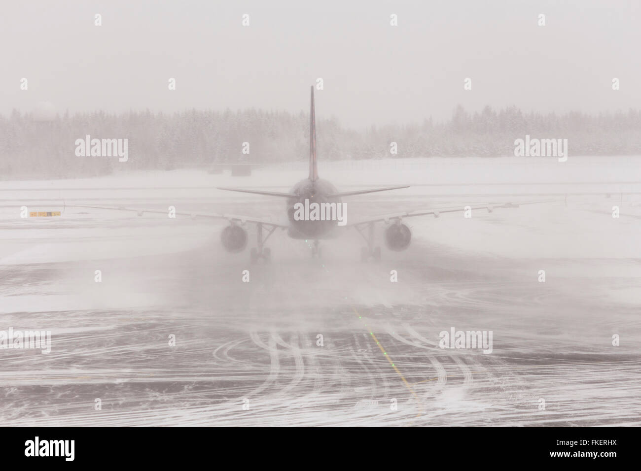 Airplane in bad weather, snow storm on snowy runway, Gardermoen airport, Oslo, Norway Stock Photo