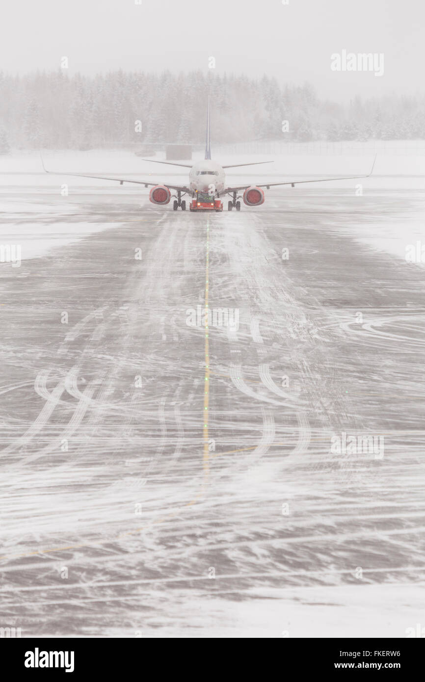 Airplane in bad weather, snow storm on snowy runway, Gardermoen airport, Oslo, Norway Stock Photo