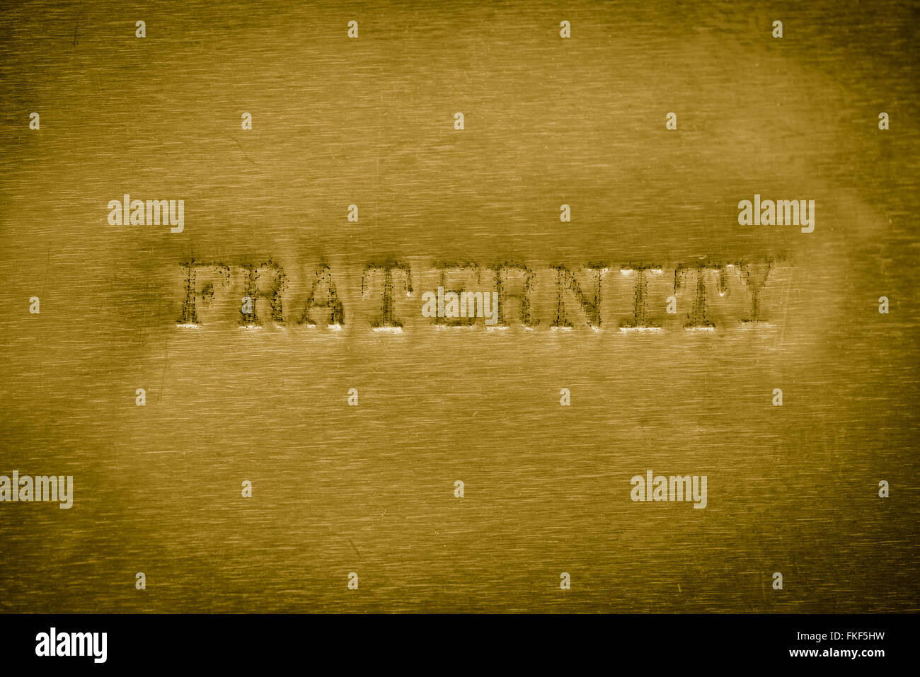 word fraternity printed on golden metallic background texture Stock