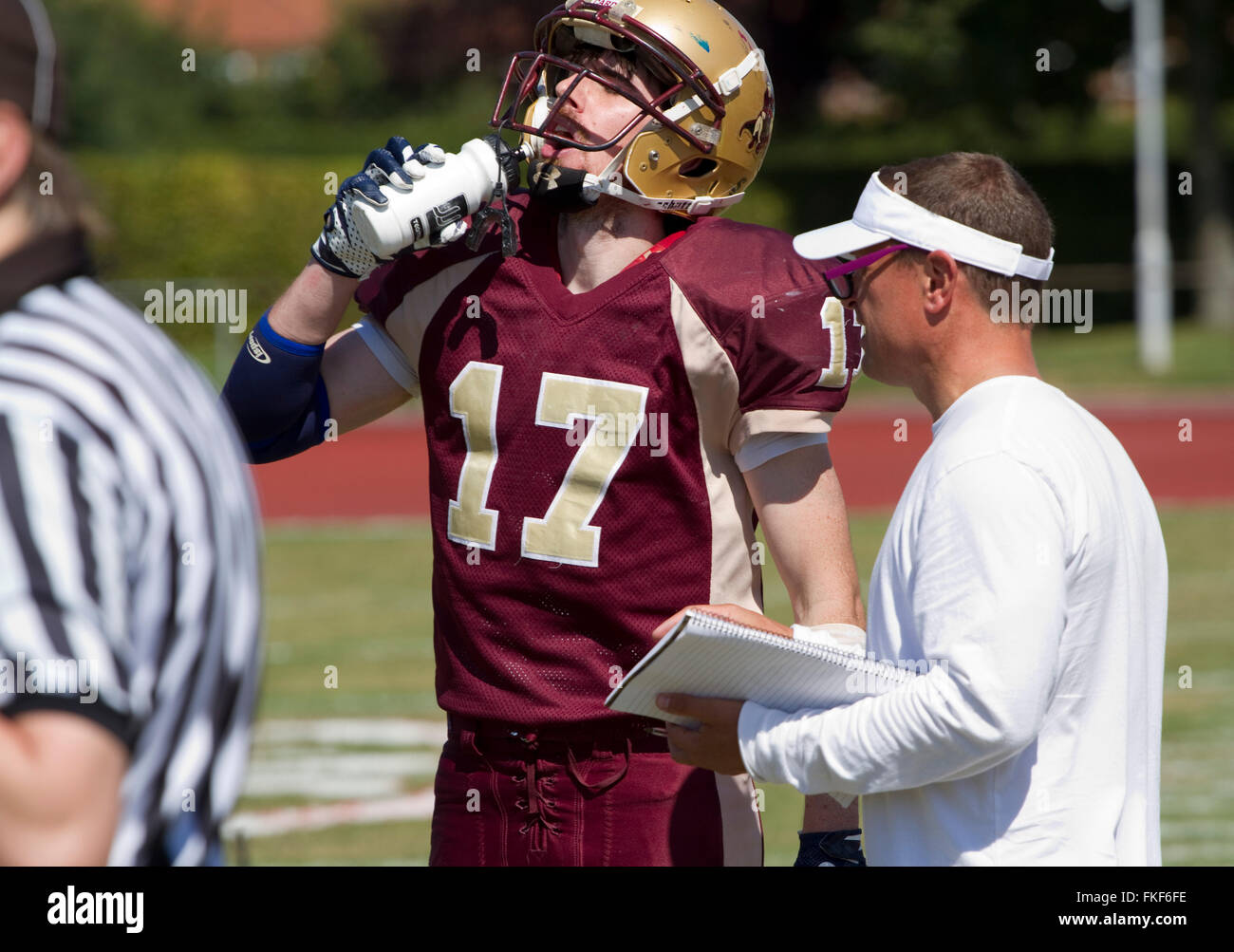 On a hot sunny day an American football player drinks from a water bottle Stock Photo