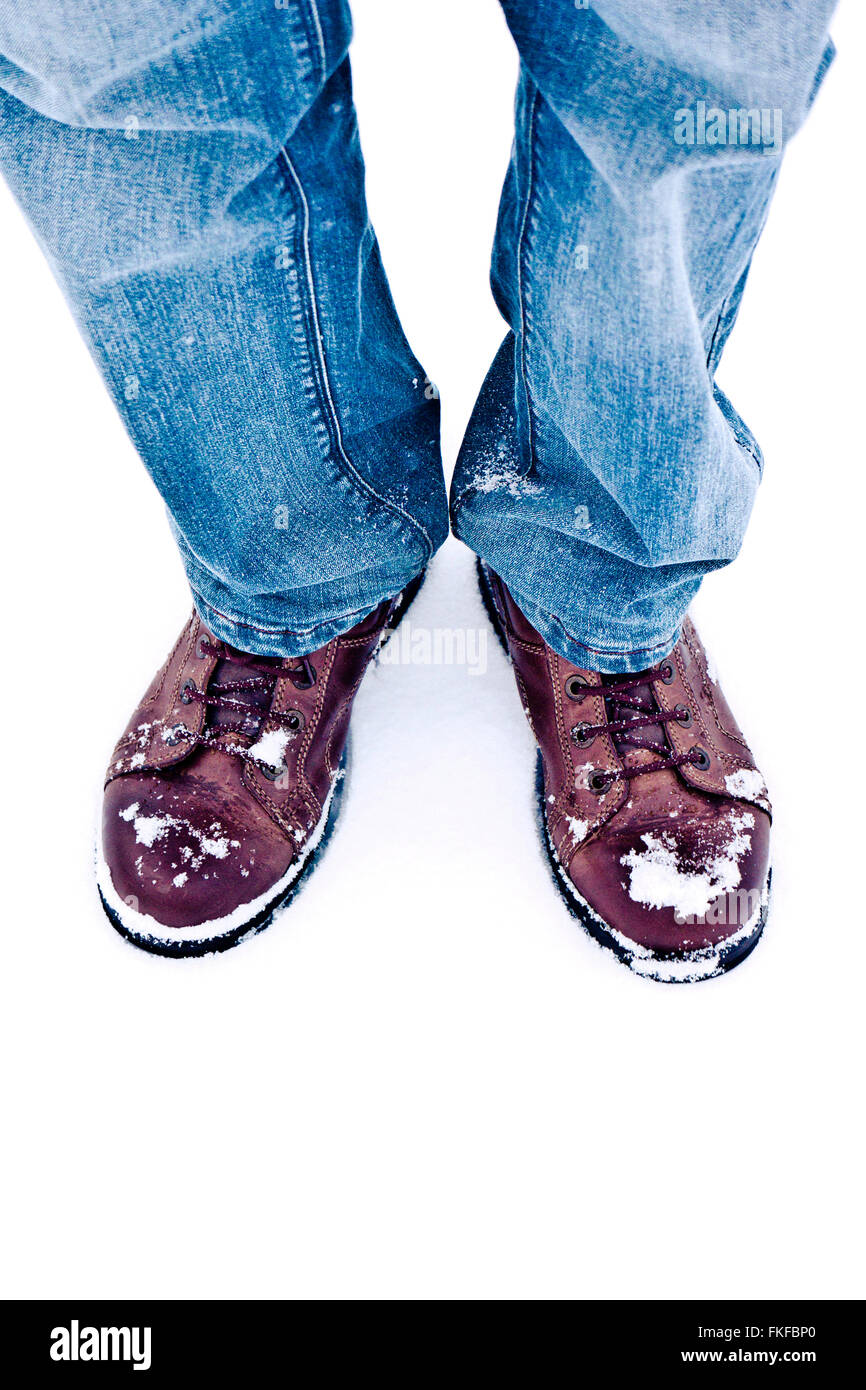 man in jeans and boots standing in the snow Stock Photo