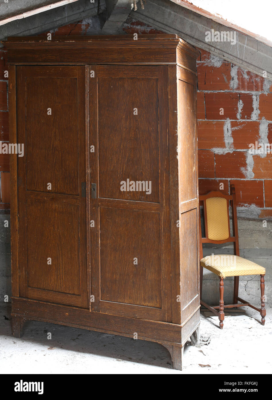 Antique Wooden Wardrobe In The Dusty Attic And An Old Chair Stock