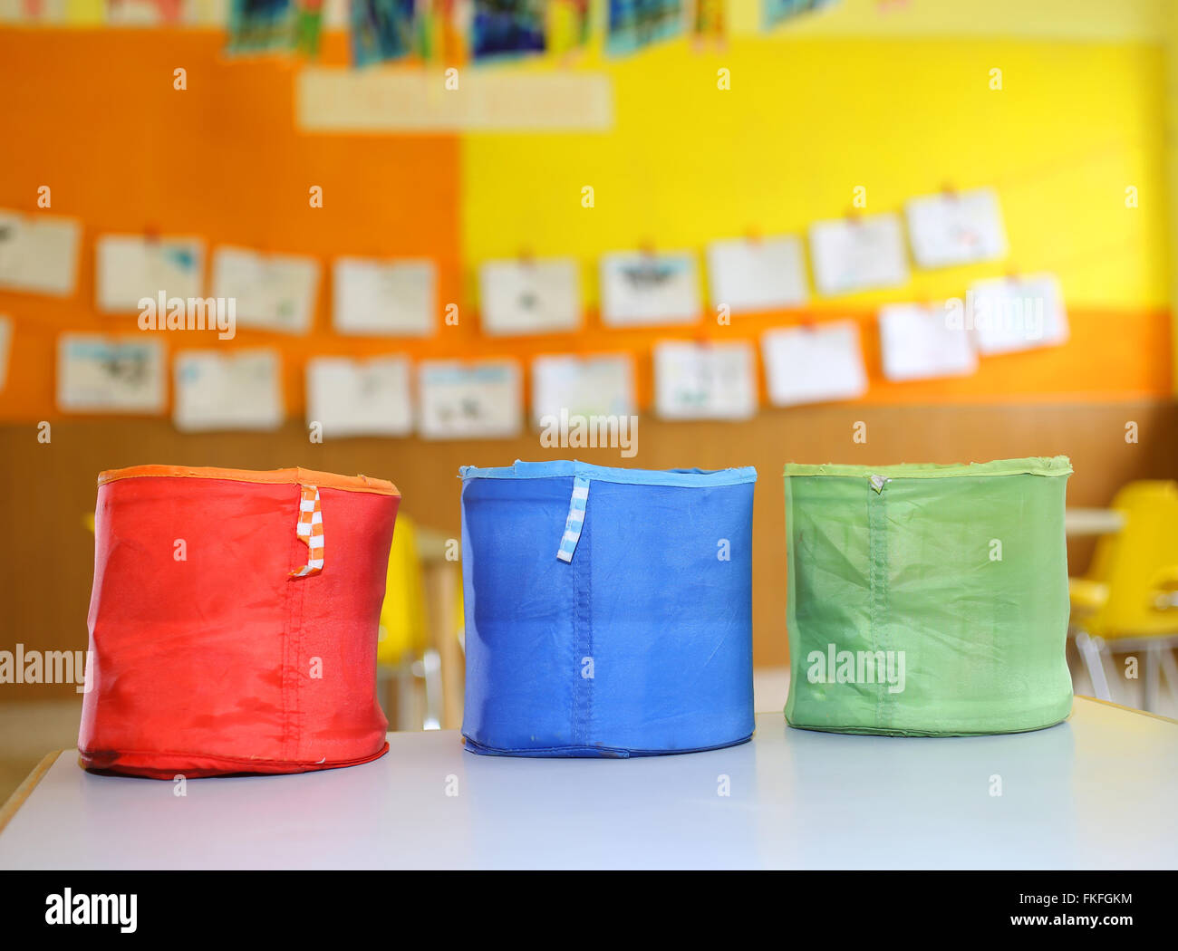 three colored fabric containers for children's toys in the classroom in the kindergarten Stock