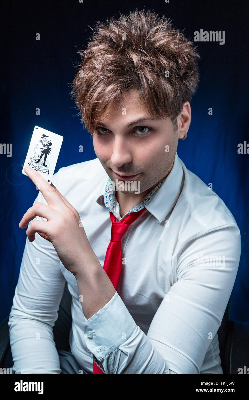 man illusionist with joker card in hand Stock Photo