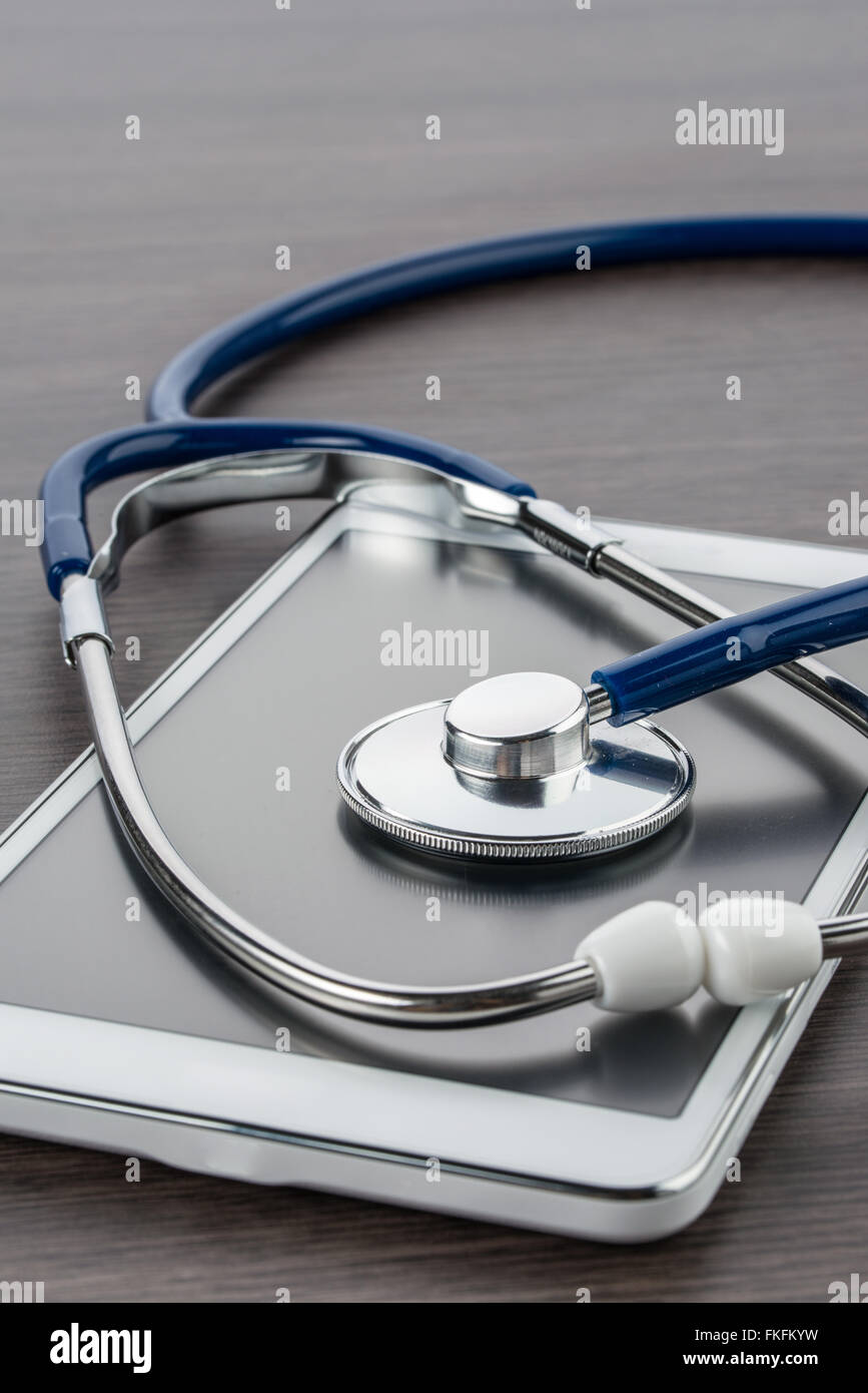 digital tablet and stethoscope on wood desk in Doctor workplace Stock Photo