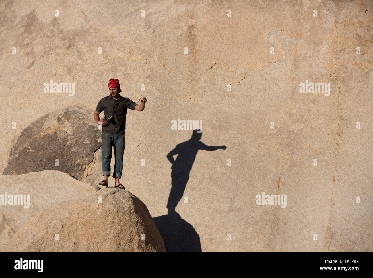 Rock climber at base of cliff, Hidden Valley, Joshua Tree National Park, California, USA Stock Photo