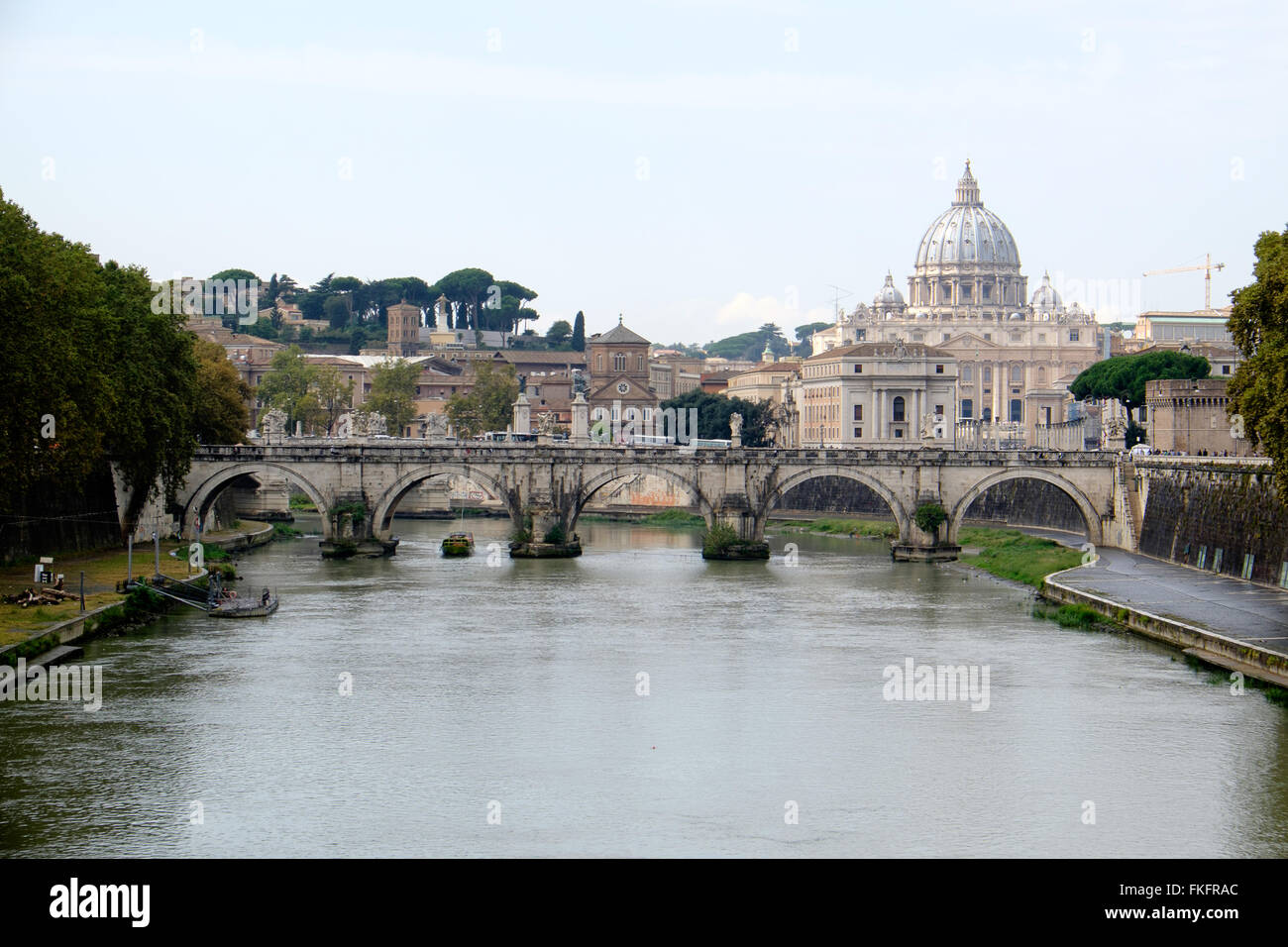 St. Peter's Basilica is seen above the Tiber River and the Ponte Sant' Angelo bridge in Rome, Italy. Stock Photo