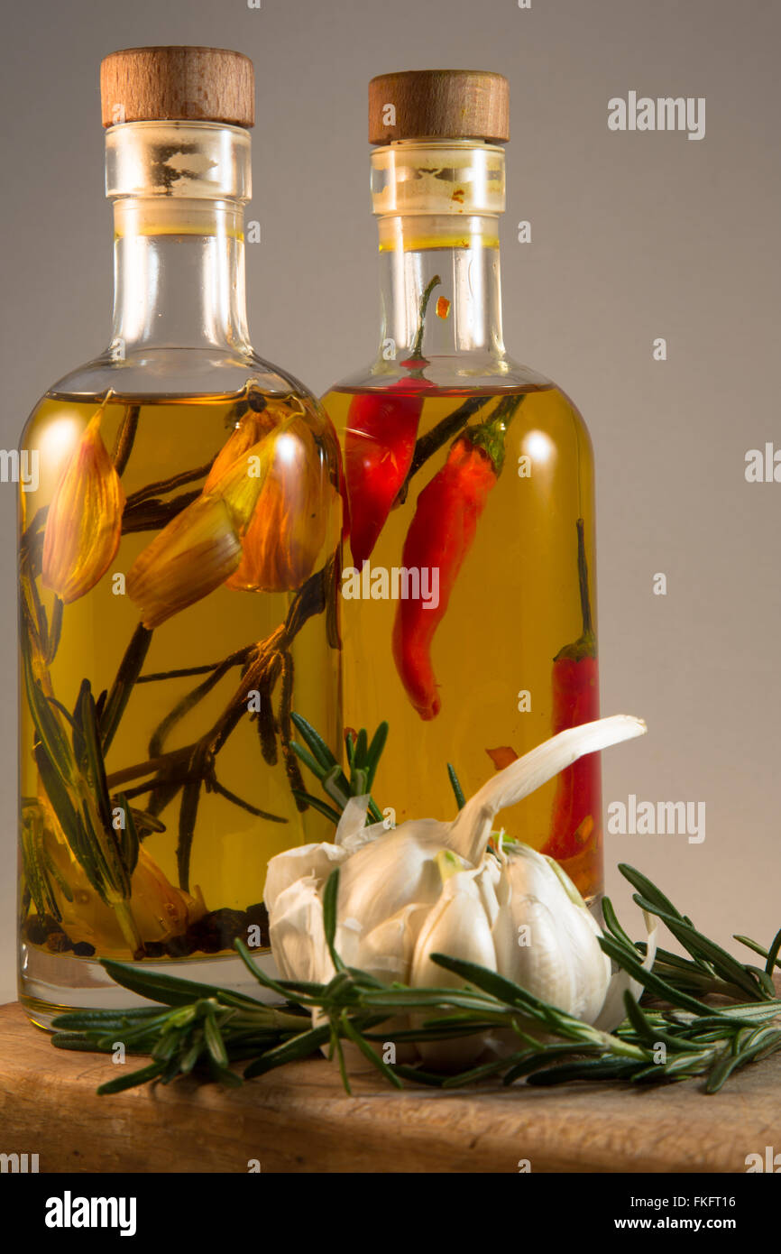 Two glass bottles of Olive Oil flavoured with herbs and spices for use ...