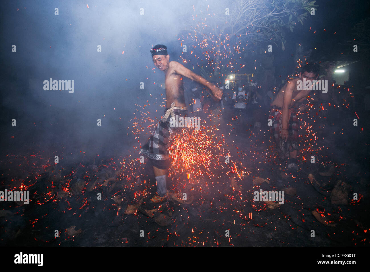 Gianyar, Indonesia. 08th Mar, 2016. Balinese man kicks up and throw the blamed coconut shell during the fire war ritual called Mesabatan Api in the day of silence called Nyepi in Banjar Nagi, Gianyar, Bali, Indonesia, on March 8, 2016. Mesabetan Api is an annual ritual of Balinese Hindus gathers symbolizes the purification of human body from the evil through the fire and held a day before Nyepi. Credit:  Reza Fitriyanto/Pacific Press/Alamy Live News Stock Photo