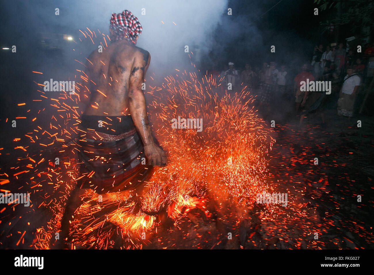 Gianyar, Indonesia. 08th Mar, 2016. Balinese man kicks up and throw the blamed coconut shell during the fire war ritual called Mesabatan Api in the day of silence called Nyepi in Banjar Nagi, Gianyar, Bali, Indonesia, on March 8, 2016. Mesabetan Api is an annual ritual of Balinese Hindus gathers symbolizes the purification of human body from the evil through the fire and held a day before Nyepi. Credit:  Reza Fitriyanto/Pacific Press/Alamy Live News Stock Photo