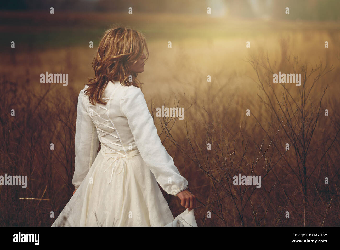 Beautiful woman walking in a field. Purity and innocence Stock Photo