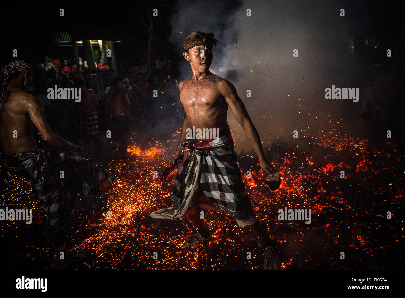 Bali, Indonesia. 08th Mar, 2016. A Balinese man gestures as he hold burned coconut husks during the 'Mesabatan Api' ritual a head of Nyepi Day on March, 2016 at Banjar Nagi in Gianyar, Bali, Indonesia. Mesabatan Api is held annually a day before the Nyepi Day of Silence, as symbolizes the purification of universe and human body trough fire. Nyepi is a Hindu celebration observed every new year according to the Balinese calendar. Credit:  Agung Parameswara/Alamy Live News Stock Photo