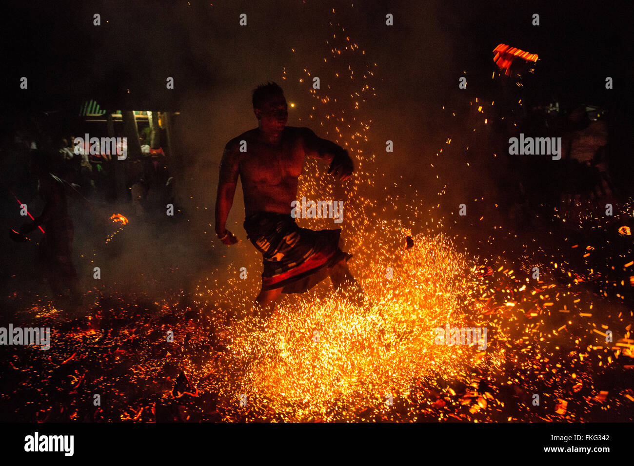 Bali, Indonesia. 08th Mar, 2016. A Balinese man kicks the burned coconut husk during the 'Mesabatan Api' ritual a head of Nyepi Day on March, 2016 at Banjar Nagi in Gianyar, Bali, Indonesia. Mesabatan Api is held annually a day before the Nyepi Day of Silence, as symbolizes the purification of universe and human body trough fire. Nyepi is a Hindu celebration observed every new year according to the Balinese calendar. Credit:  Agung Parameswara/Alamy Live News Stock Photo