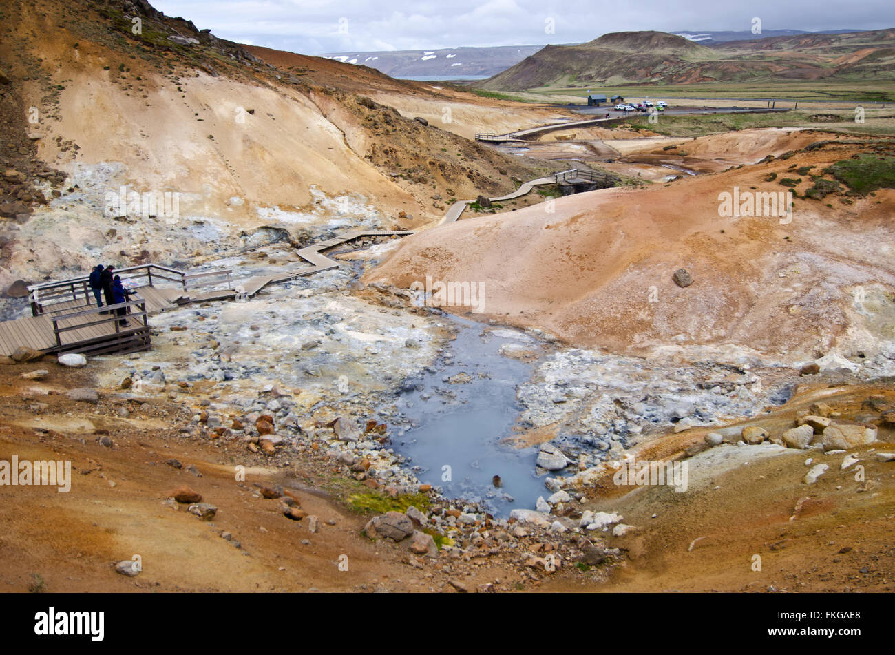 People watching boiling mud pond at Krysuvik geothermal area, Iceland Stock Photo