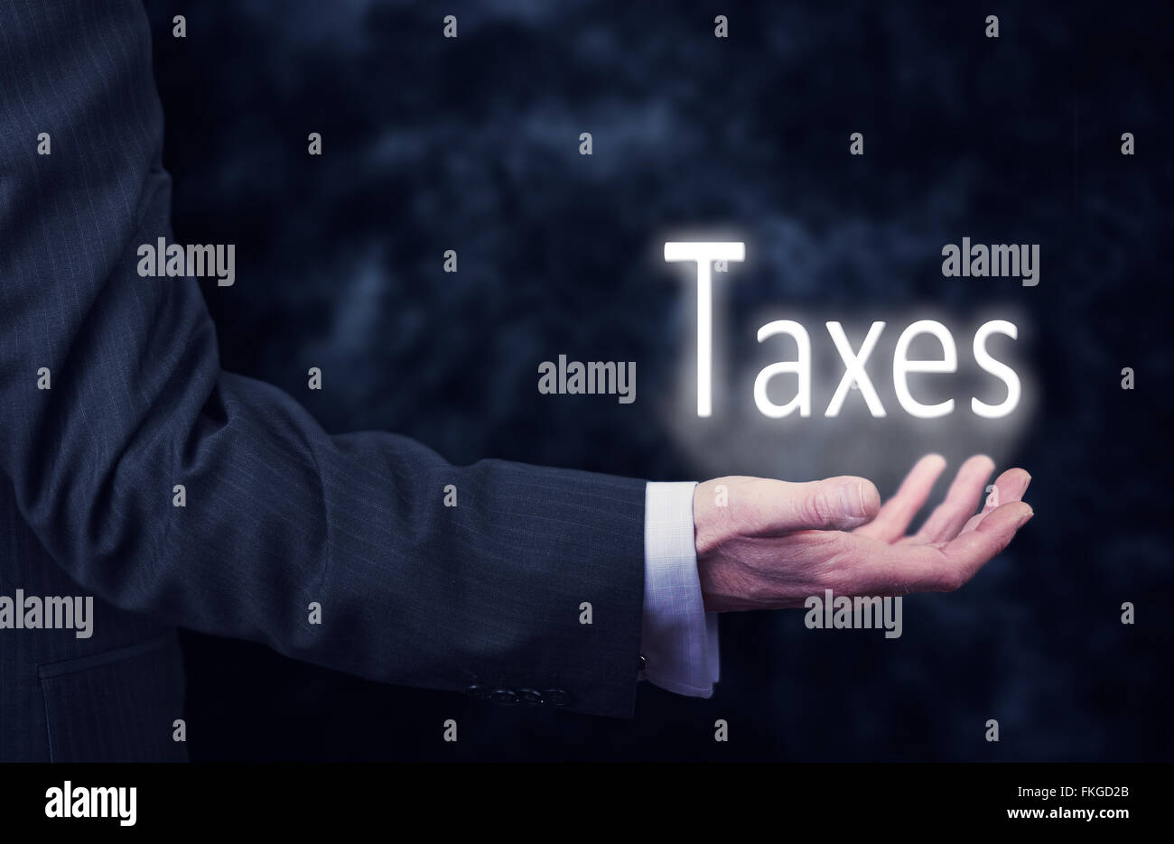Businessman pressing an Taxes concept button. Stock Photo